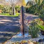 Tall Surf Symphony corten sculpture casting artistic shadows in evening garden light